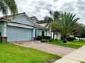 A beautiful house with a two-car garage, well-maintained lawn, and large palm trees in front at 1474 Lake Side Ave, Davenport, FL 33837