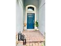 Inviting entryway with a blue front door, decorative plants, and stylish decor at 1474 Lake Side Ave, Davenport, FL 33837