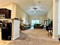 Open-concept living area featuring plush carpeting and access to the backyard at 1474 Lake Side Ave, Davenport, FL 33837