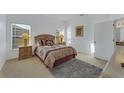 Cozy bedroom featuring neutral carpet, two windows, and an ensuite bathroom with a granite vanity at 149 Emeraldview Ave, Davenport, FL 33897