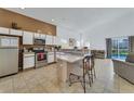 Open kitchen with stainless steel appliances, island, tile flooring, and natural light from a sliding glass door at 149 Emeraldview Ave, Davenport, FL 33897