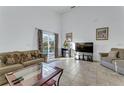 Bright living room with tile flooring, comfortable seating, and sliding glass doors to the outdoor pool at 149 Emeraldview Ave, Davenport, FL 33897