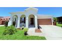 Charming home featuring an arched entryway and a two-car garage, all set on a beautifully landscaped lot at 1726 Brassie Ct, Kissimmee, FL 34746