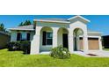 Inviting single-Gathering home featuring an arched entryway, a two-car garage, and verdant lawn at 1726 Brassie Ct, Kissimmee, FL 34746