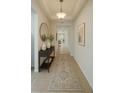 Inviting hallway with decorative table, mirror, and neutral colors creates an elegant and welcoming entrance at 1726 Brassie Ct, Kissimmee, FL 34746