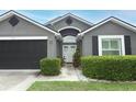 Close up of the front of the house showing the door and trimmed hedges at 1825 Needham Rd, Apopka, FL 32712