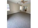 Spacious bedroom with neutral carpet, bright windows, ceiling fan, and doorway to bathroom at 1880 N Crystal Lake Dr # 3, Lakeland, FL 33801