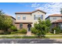 Charming two-story home featuring a stone facade, terracotta roof, and lush landscaping at 1978 Fishtail Fern Way, Ocoee, FL 34761
