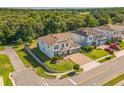 An aerial view showcasing a well-maintained home with lush landscaping and a brick-paved driveway in a serene neighborhood at 2539 Auburn Ridge Dr, Apopka, FL 32712