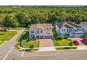 Aerial view of a home with manicured lawn and a brick paved driveway on a well-maintained street at 2539 Auburn Ridge Dr, Apopka, FL 32712