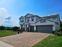 View of a two-story home with an attached two-car garage, complimented by a brick driveway at 2539 Auburn Ridge Dr, Apopka, FL 32712
