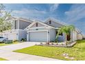 Charming single-story home featuring a gray facade, well-maintained landscaping, and an attached two-car garage at 26271 Feathergrass Cir, Leesburg, FL 34748