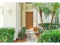 Inviting entryway with a wooden door framed by lush greenery and a charming stone bench at 2648 Daulby St, Kissimmee, FL 34747