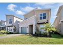 Stylish exterior view of the house highlighting the desert landscaping, modern design, and colored garage door at 2821 Bookmark Dr, Kissimmee, FL 34746