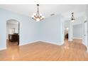 Bright dining room boasting wood floors, elegant lighting, and arched doorways, perfect for entertaining guests at 3813 Goldenglow Dr, Orlando, FL 32828