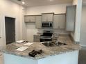 Modern kitchen features granite countertops, stainless steel appliances, gray cabinetry, and a stylish sink at 4586 Se 25Th Loop, Ocala, FL 34480