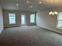 Spacious living room featuring plush carpeting, recessed lighting, and multiple windows with backyard views at 4586 Se 25Th Loop, Ocala, FL 34480