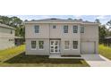 Two-story home boasts a symmetrical design with a well-manicured lawn and attached one-car garage at 4905 Pall Mall E St, Kissimmee, FL 34758