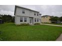 Beautiful two-story home featuring a green lawn, attached garage, and neutral gray color scheme at 4905 Pall Mall E St, Kissimmee, FL 34758