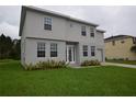 Beautiful two-story home featuring a green lawn, attached garage, and neutral gray color scheme at 4905 Pall Mall E St, Kissimmee, FL 34758