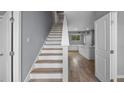 Bright interior showcasing stairs with wood treads, leading into an open-concept kitchen and living area at 4905 Pall Mall E St, Kissimmee, FL 34758
