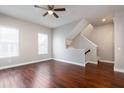 Bright living room featuring hardwood floors, a ceiling fan, and stairway to the upper level at 625 Pavia Loop, Lake Mary, FL 32746