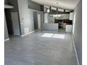 Open living space showcasing the kitchen with stainless steel appliances, dining area, and tile flooring at 6625 Cherry Grove Cir, Orlando, FL 32809