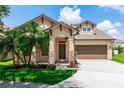 Inviting home with a well-maintained lawn, mature palm trees, and a welcoming entrance at 6728 Duncaster St, Windermere, FL 34786