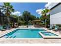 Backyard featuring a pool, spa, tiki bar, chess set, and cabana, creating an inviting and entertaining outdoor oasis at 8180 Valhalla Ter, Reunion, FL 34747