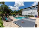 Backyard features a pool, ping pong table, spa, tiki bar, cabana, chess set, and lush landscaping for entertainment at 8180 Valhalla Ter, Reunion, FL 34747