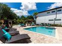 Backyard featuring a pool, spa, lounge chairs, tiki bar, cabana, chess set, and lush landscaping for ultimate relaxation at 8180 Valhalla Ter, Reunion, FL 34747