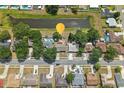 Aerial view of a neighborhood highlighting the proximity to a pond and nearby residential properties at 2527 Christine Dr, Kissimmee, FL 34744