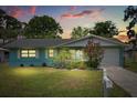 Inviting single-story home featuring a well-manicured lawn and colorful landscaping at dusk at 1007 3Rd St, Port Orange, FL 32129