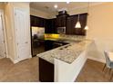 Kitchen features dark cabinets, granite counters, and stainless steel appliances at 10631 Village Lake Rd, Windermere, FL 34786