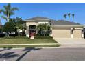 Lovely home with well-kept lawn, palm trees, attractive stone accents, and a three-car garage at 13016 Islamorada Dr, Orlando, FL 32837
