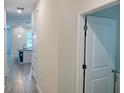 Hallway with wood-look flooring leading to a kitchen with a waterfall countertop peninsula at 1308 Shinnecock Hills Dr, Davenport, FL 33896