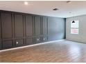 Stylish living room features wood-look tile, a decorative accent wall and natural light at 1308 Shinnecock Hills Dr, Davenport, FL 33896