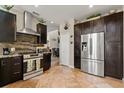 Modern kitchen showcasing stainless steel appliances, dark cabinetry, and a beautiful stone backsplash at 16 Sawfish Ct, Kissimmee, FL 34759
