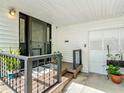 Inviting front porch features a black security door and wrought iron railings with potted plants adding a touch of greenery at 171 Stanley Bell Dr, Mount Dora, FL 32757