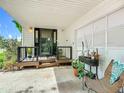 Inviting front porch with plants, a decorative chair, and a black-trimmed front door, creating a cozy entryway at 171 Stanley Bell Dr, Mount Dora, FL 32757