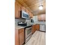 Well-lit kitchen featuring stainless steel appliances, granite counters, and wood cabinets at 1881 Cottonwood St, Orange City, FL 32763