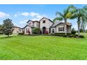 Elegant home with lush green lawn and mature palm trees, offering curb appeal and a welcoming feel at 2260 Grayling St, Orlando, FL 32820