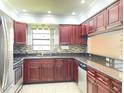Updated kitchen features stainless steel appliances, granite countertops, and custom wood cabinets at 2316 E Margarita Ct, Kissimmee, FL 34741