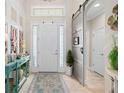 Bright foyer featuring a decorative rug and a sliding barn door at 2554 Stargrass Cir, Clermont, FL 34715
