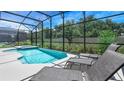 Relaxing screened-in pool and jacuzzi with lounge chairs for sunbathing and relaxation at 266 Marcello Blvd, Kissimmee, FL 34746