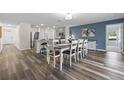 Open-concept dining area featuring stylish wood flooring, a modern table set, and adjacent kitchen at 2701 Sw 153Rd Ln, Ocala, FL 34473
