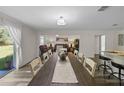 Bright dining area with long wooden table, flows seamlessly into the living room, perfect for entertaining at 2701 Sw 153Rd Ln, Ocala, FL 34473