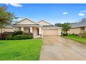 Charming single-story home featuring a well-manicured lawn and a two-car garage at 305 Grande Lake Dr, Daytona Beach, FL 32124