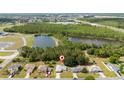 Aerial shot of a home next to a pond and wooded area, near residential community at 313 Greenwich Ct, Kissimmee, FL 34758