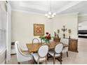 Elegant dining area features a stylish chandelier, decorative art, and comfortable seating for six at 31754 Red Tail Blvd, Sorrento, FL 32776